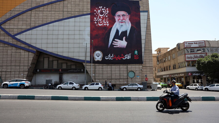 Conductores iraníes pasan en coche junto a una valla publicitaria del difunto líder supremo iraní, el ayatolá Ali Khamenei, en una calle de Teherán, Irán, el 9 de julio de 2026. (EFE)